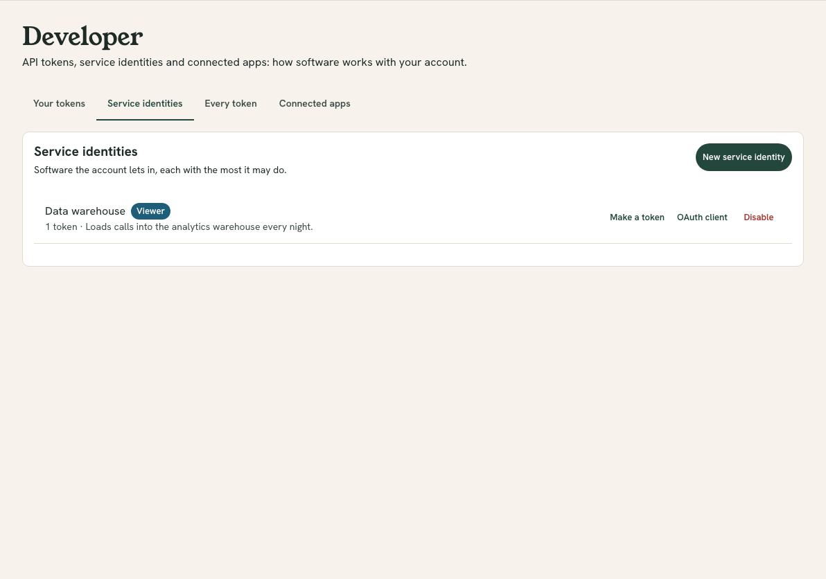 The Service identities tab listing identities with a role chip, how many tokens each has and what it is for, with Make a token, OAuth client and Disable buttons on each, and a New service identity button above.